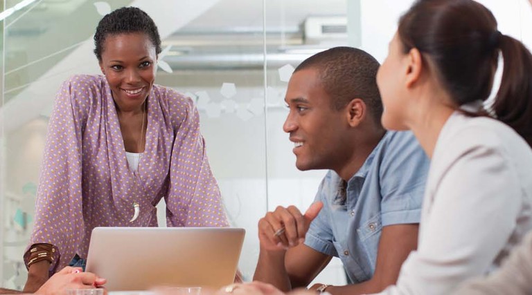 A diverse group of people around a conference room table.