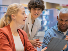 Three people gather around a device